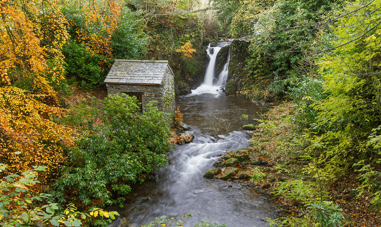 The Grot, a small stone building, sits beside a waterfall